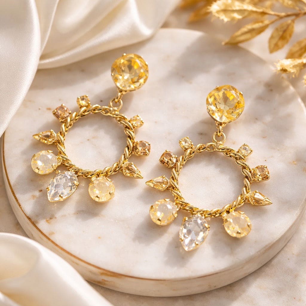 Emily oorbellen silk gold met Swarovski kristallen - close-up van champagne kleurige statement oorbellen in goudverguld design