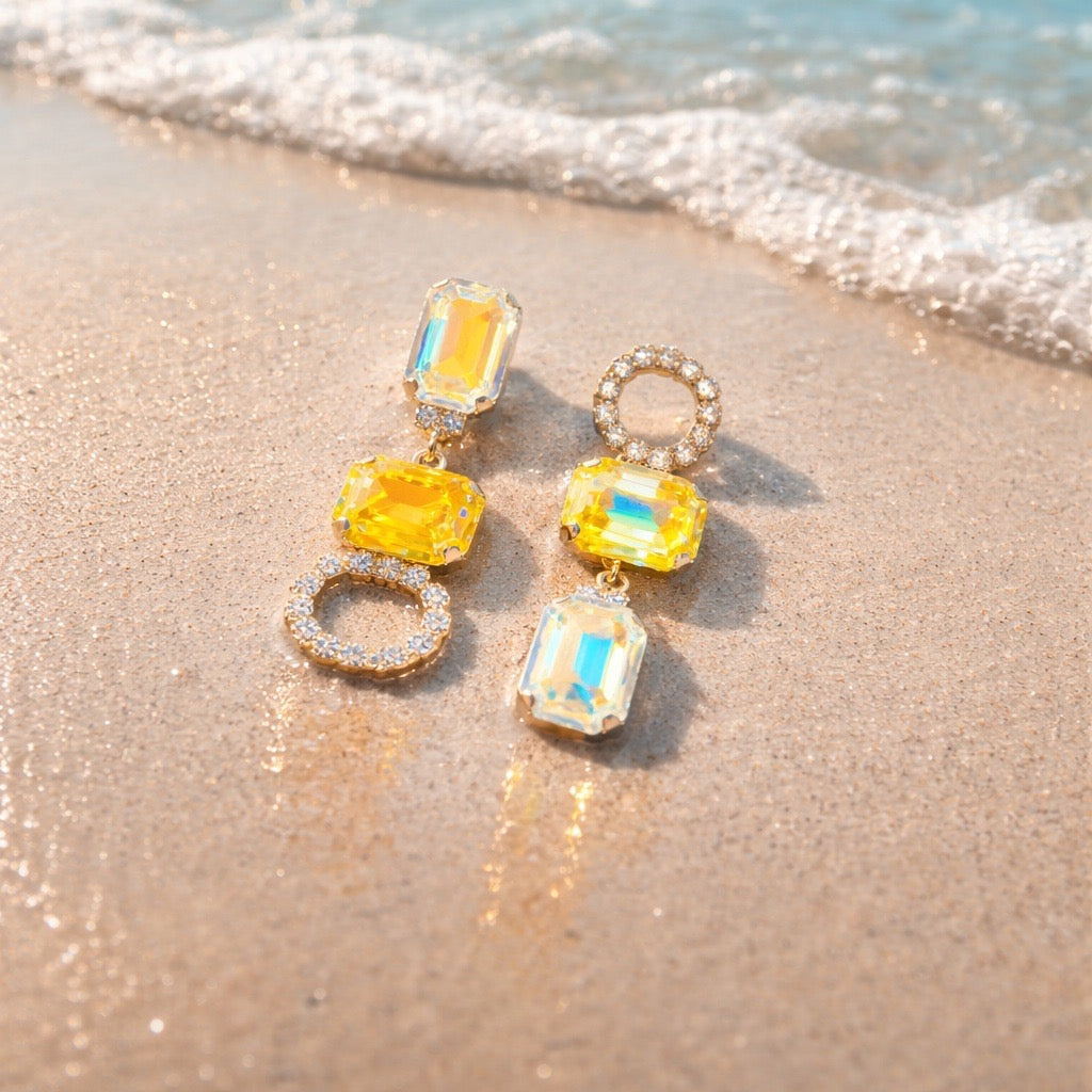 Luana Yellow Gold statement oorbellen met gele kristallen op het strand - DAMICE Jewelry unieke sieraden